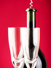 Glass of red wine with glass and bottle