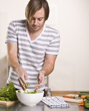 Attractive male making salad