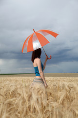 girl with umbrella at wheat field in rainy day