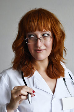Female doctor looks away and holds stethoscope