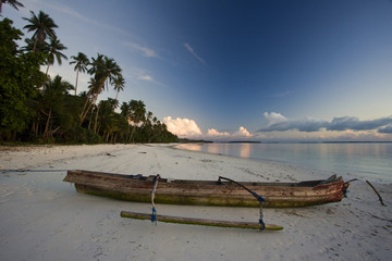 White sand beach with boat at sunset