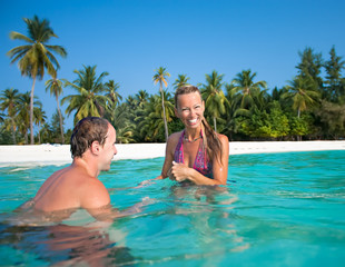 Fototapeta na wymiar attractive couple having fan on the tropical beach