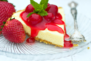 Cheese cake with cherry sauce, mint and fresh strawberries.