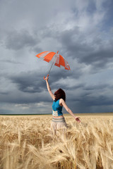girl with umbrella at wheat field in rainy day