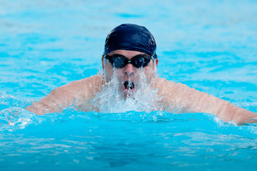 dynamischer Schwimmer im Pool holt Luft