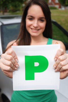 Happy teenager holding 'P' plate