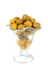 Green olives in a glass vase on a white background
