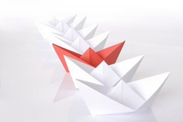Red paper boat in the line
