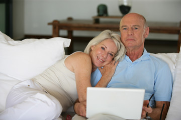 Portrait d'un couple de seniors avec ordinateur portable