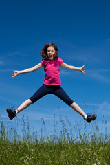 Girl jumping, running against blue sky