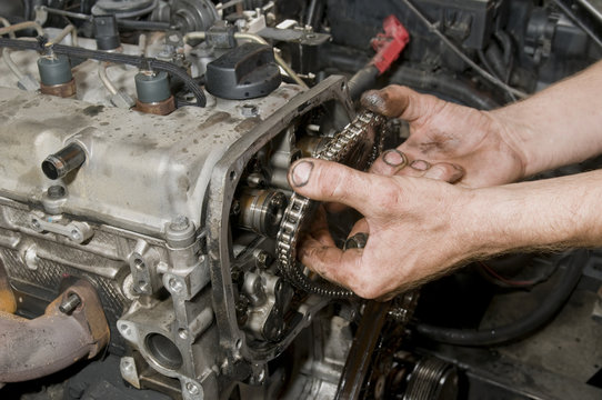 Repairing of diesel engine, close up of worker hands