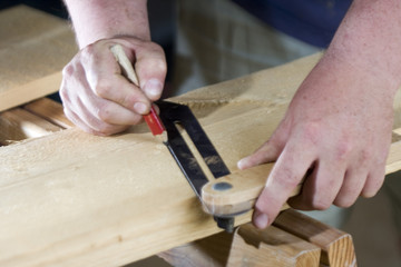 worker drawing on wood plank