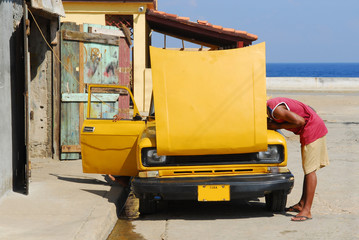 cartrouble : man fixing car on cuba