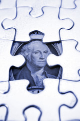 One dollar U.S. banknote behind puzzle