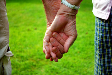 elderly couple holding hands