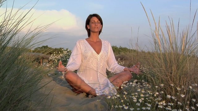 Donna medita in spiaggia