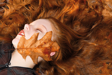 young girl with red hair in autumn forest