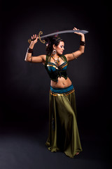 Attractive bellydancer in tribal costume and holding sword