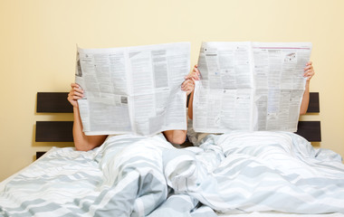 couple newspaper in bed