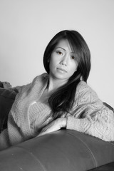 Pretty asian american woman resting on a couch