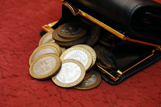 coins and a purse on a red background