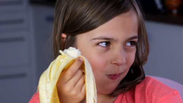 fillette go&ucirc;tant sa banane