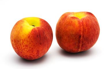 Two tasty juicy peaches on a white background