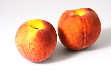 Fototapeta na wymiar Two tasty juicy peaches on a white background