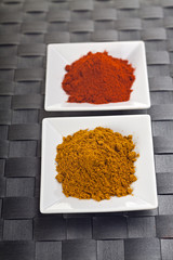 Paprika und Currypulver auf kleinen Tellern