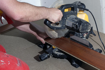carpenter working with a saw for flooring