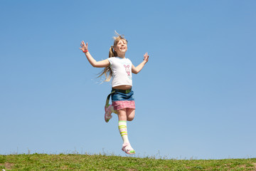 Little girl jumping against beautiful sky