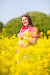 Fototapeta premium Pretty smiling girl relaxing on green meadow full of flowers. So