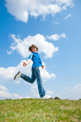 Pretty smiling girl relaxing on green meadow full of flowers. So