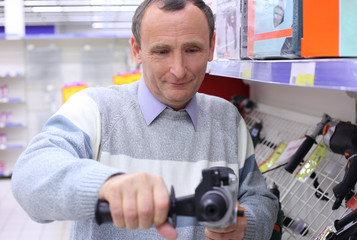 elderly man in shop with drill in hands