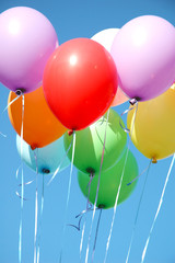 Many multi-colored balloons on a background of the blue sky