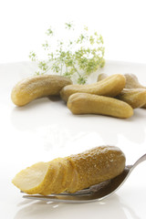 eine angeschnittene Gewuerzgurke auf einer Gabel