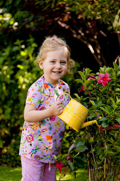 Kind mit Gie&szlig;kanne beim Blumen giessen