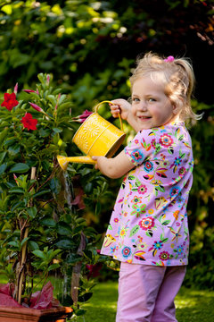 Kind mit Gie&szlig;kanne beim Blumen giessen