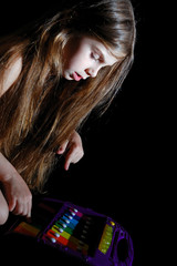 girl with long dark hair playing colorful xylophone