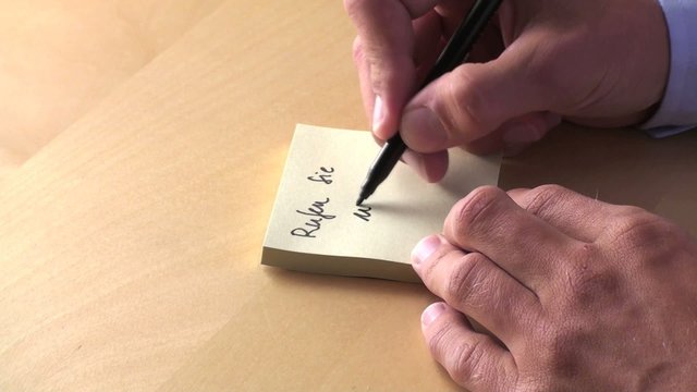 "Rufen Sie uns an!" geschrieben auf Notizzettel