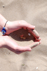 Sand falling through a womans hand