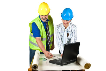 Architects working in office on plans and laptop