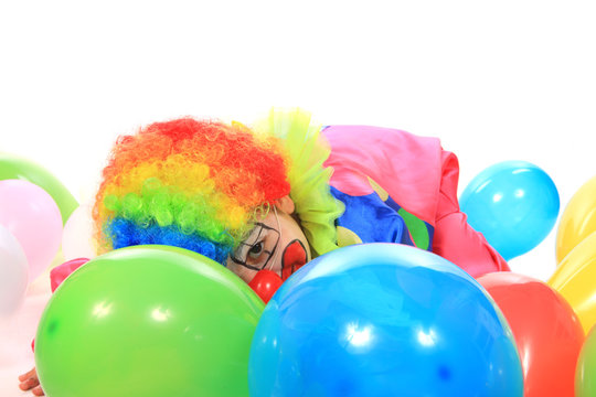 Petit clown cach&eacute; par des ballons