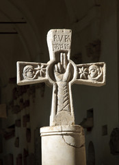Kreuz aus Stein mit religiösen Motiven