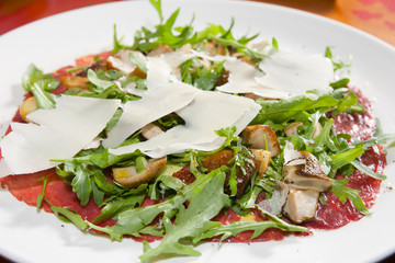 Salad of prosciutto, mushrooms, ruccola and cheese