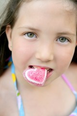 Beautiful teen portrait eating a candy heart