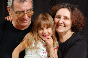 laughing happy grandparents with  grandchild showing tongue