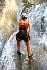 Woman climbing a waterfall