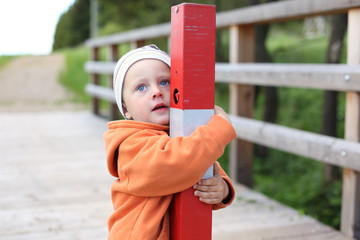 Little boy hugging post