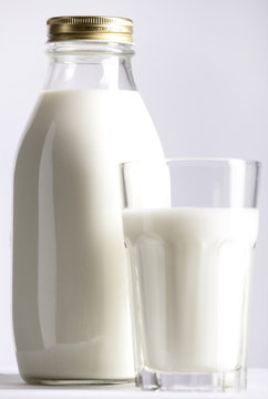 Glass and Bottle of fresh milk,  focus on the bottle.